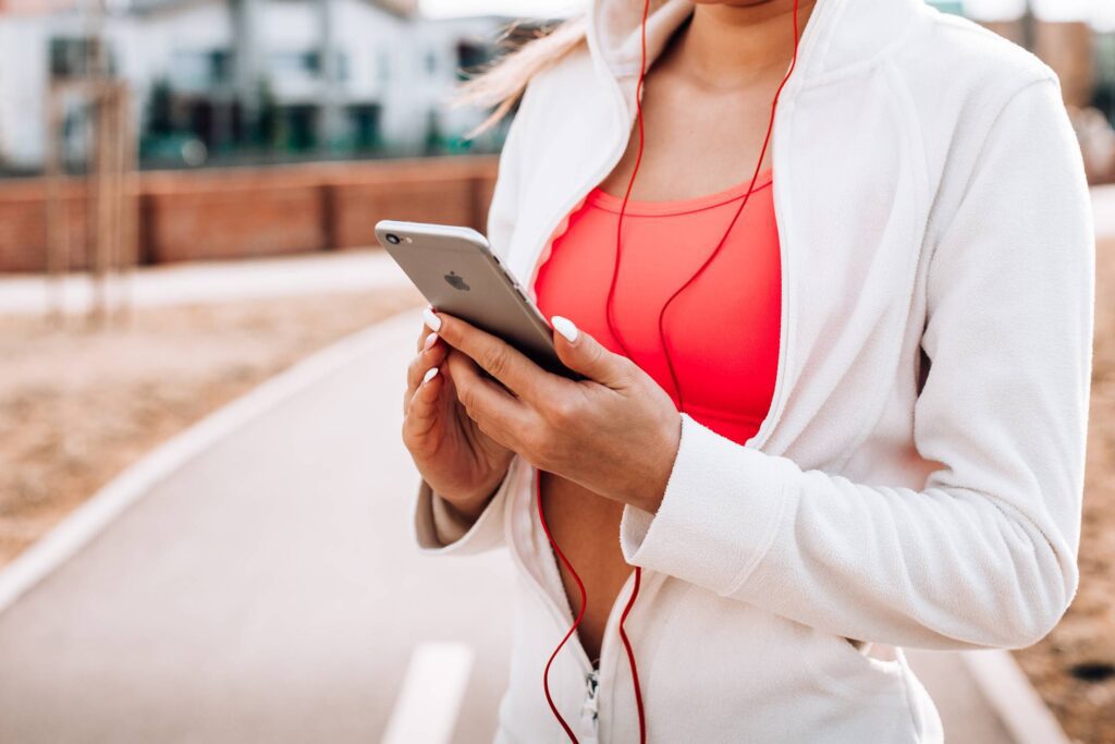 Fit Girl Listening to Music on Her iPhone Free Photo