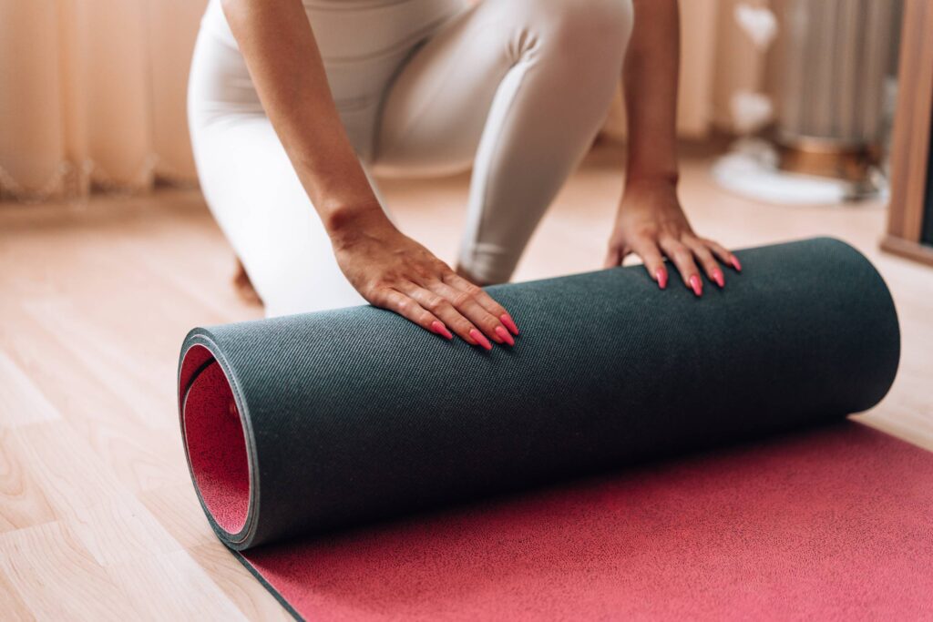 Fit Woman Rolls Her Exercise Yoga Mat at Home Free Photo