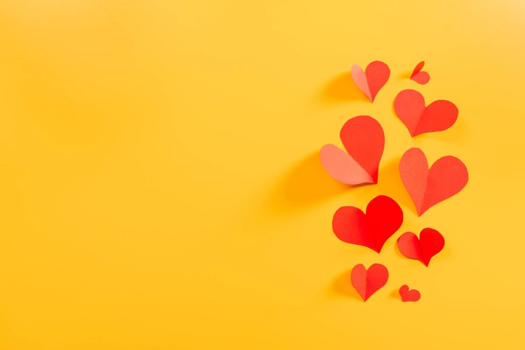 Flying Hearts on Yellow Background Free Photo