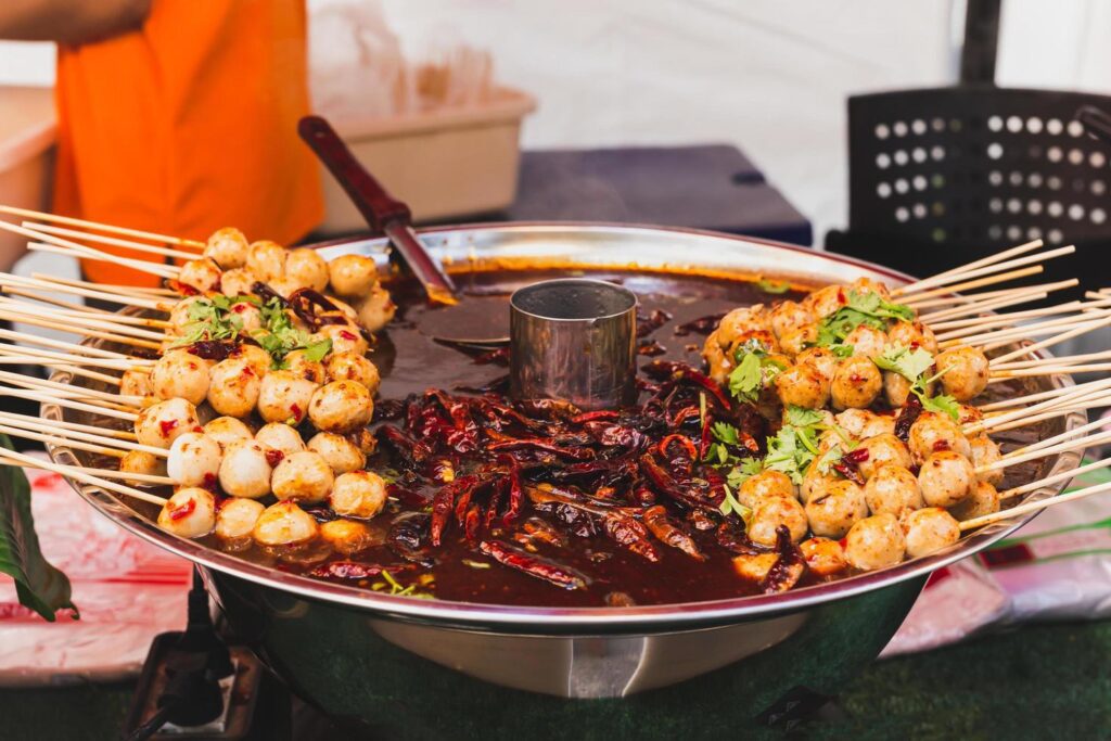 Food vendor pork meatballs in skewer with sweet chili sauce in a tray. Stock Free