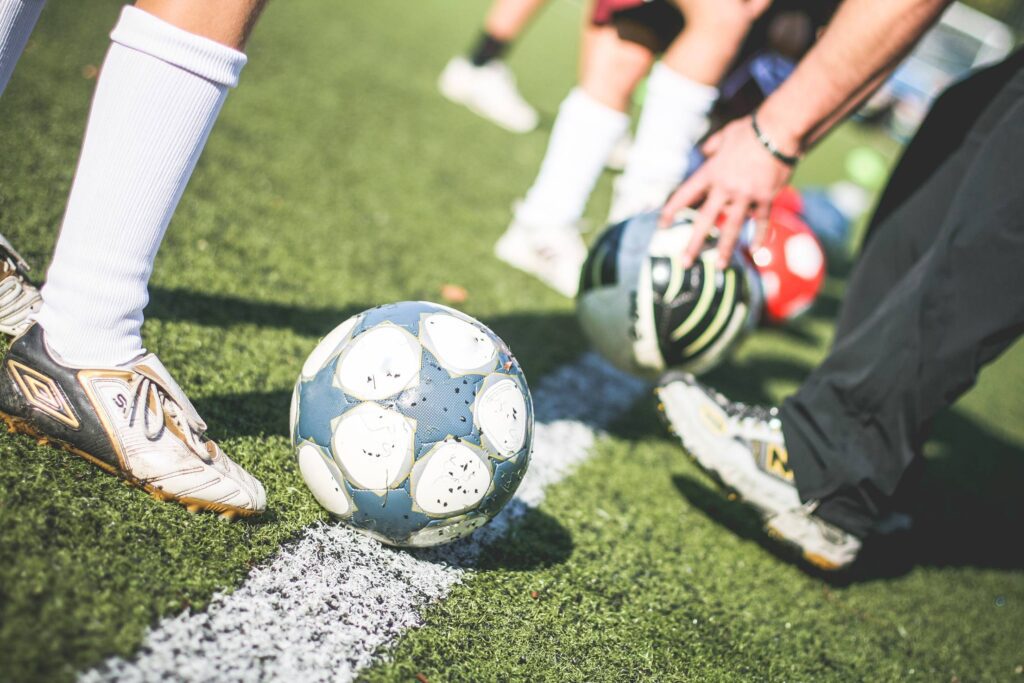 Football Field Training Players with Soccer Ball Free Photo