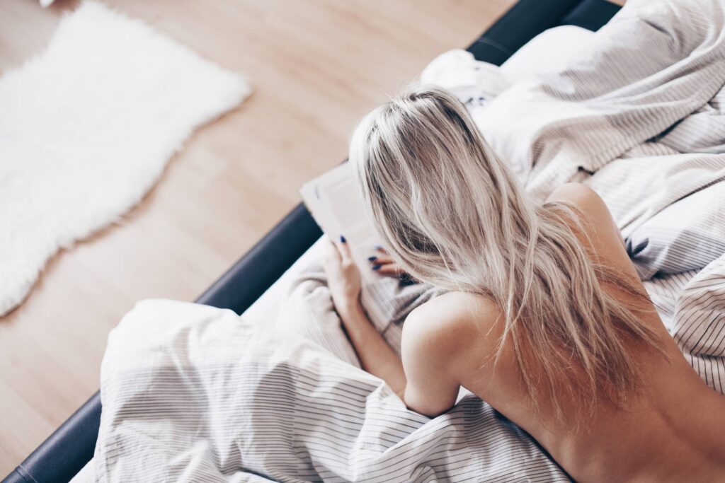 Free Spirit Woman Reading a Book in Bed Free Photo