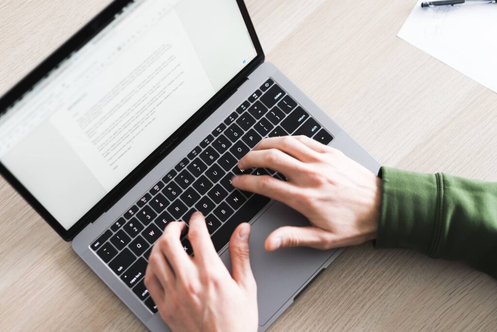 Freelance Copywriter Working on His Silver Laptop Free Photo