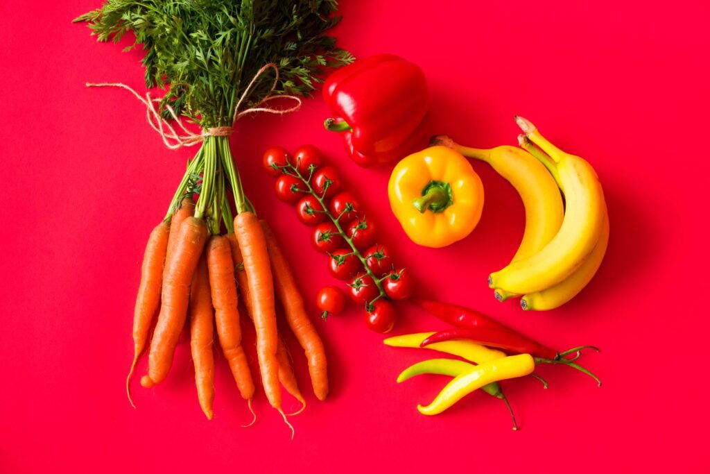 Fresh Fruits and Vegetables on Red Background Still Life Free Photo