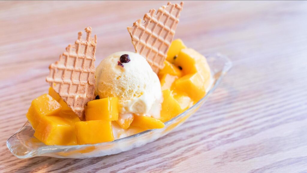 Fresh mango shaved ice with a scoop of ice cream and juice sauce in summer restaurant, lifestyle, popular food in Taiwan, close up. Stock Free