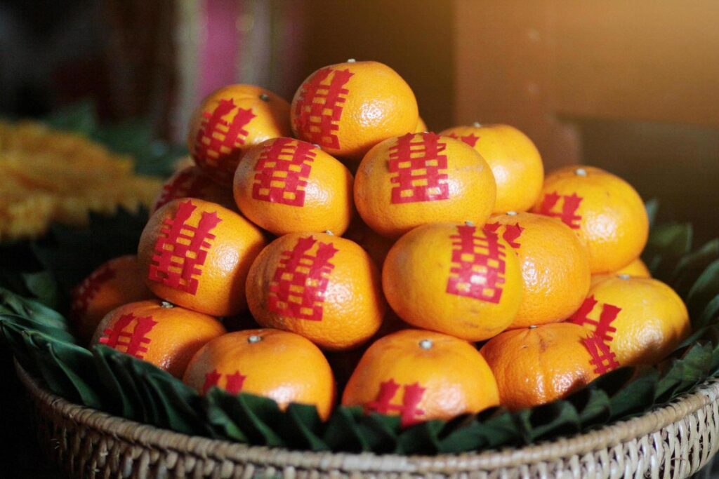 Fresh orange on banana leaves in wicker food tray. Chinese tradition in event and wedding ceremony Stock Free