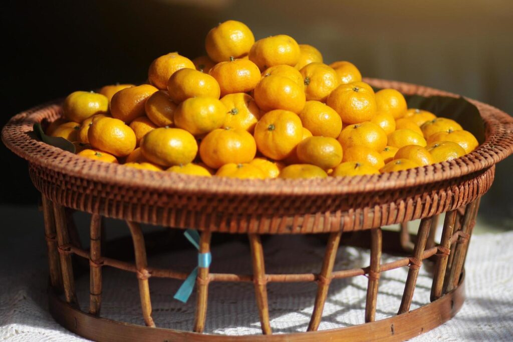 Fresh orange on banana leaves in wicker food tray. Thai buffet food tradition in event and wedding ceremony Stock Free