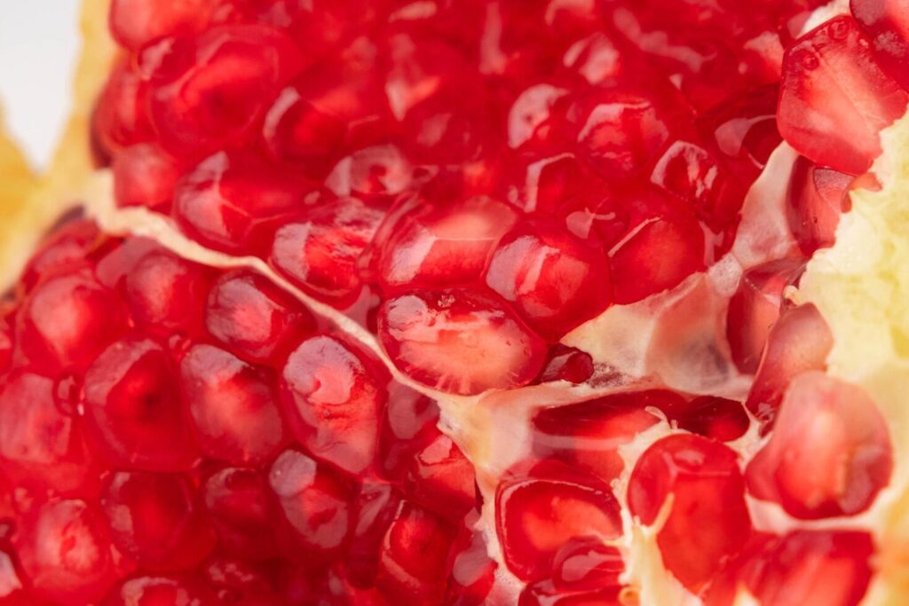 Fresh ripe pomegranate isolated on white background. close up of juicy pomegranate cut in half. Ripe fruit is a healthy food. Stock Free