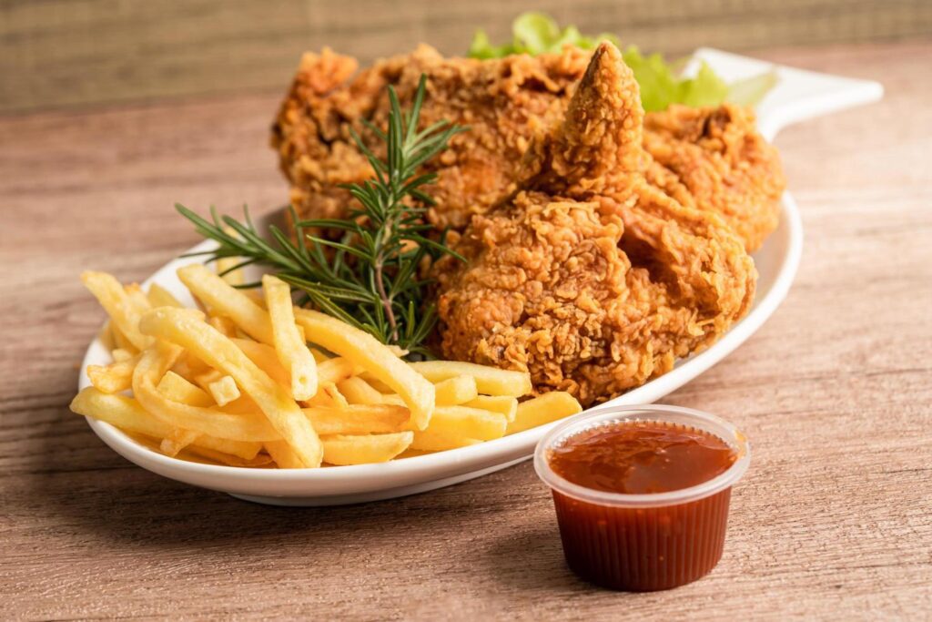 Fried chicken and potato chip with rosemary leaf, Junk food high calorie served on white plate Stock Free