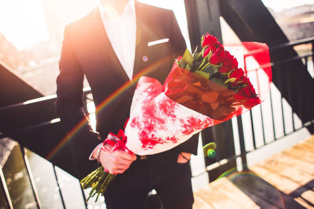 Gentleman Holding a Bouquet of Roses and Waiting for His Wife Free Photo