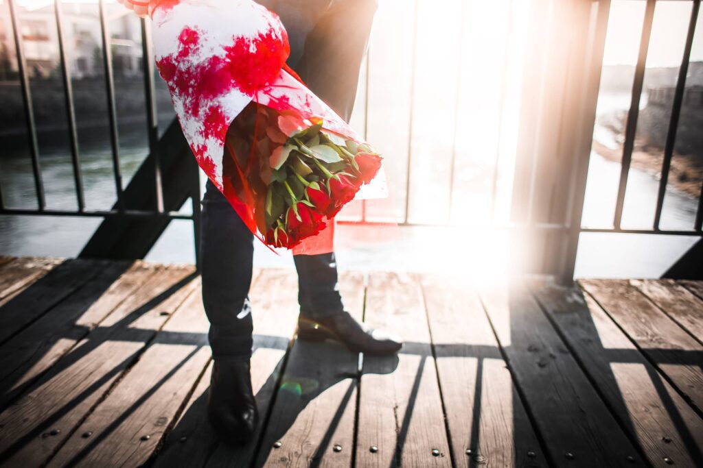 Gentleman with Roses Waiting on a Bridge Free Photo