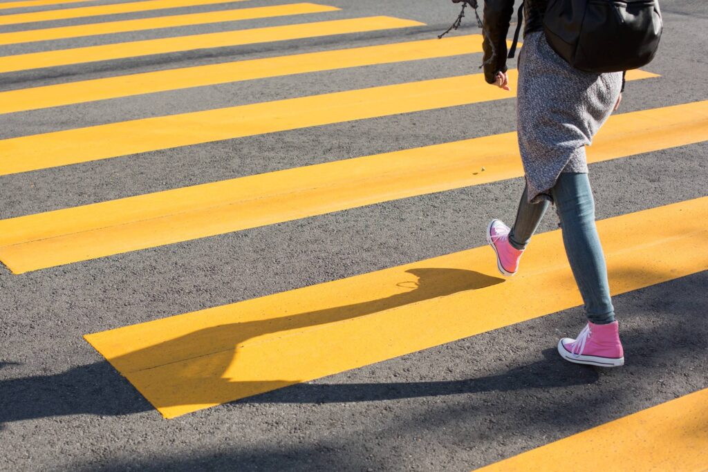 Girl Crossing Street on a Yellow Crosswalk Free Photo