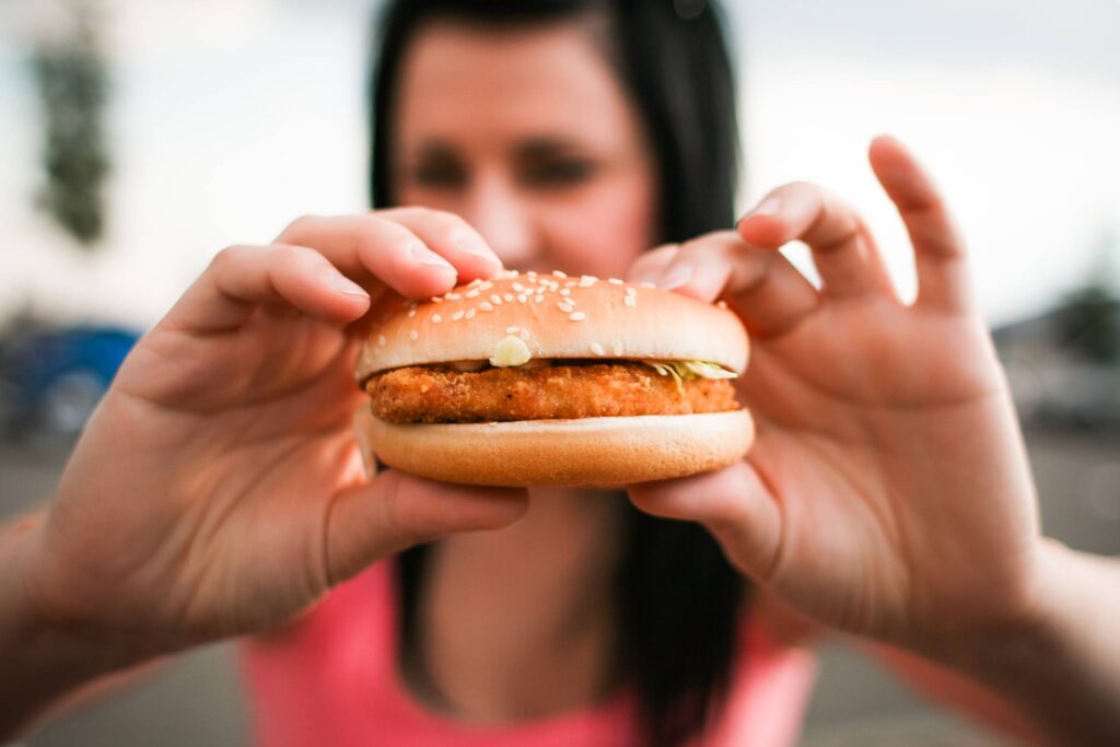 Girl holding Hamburger in her Hands Free Photo