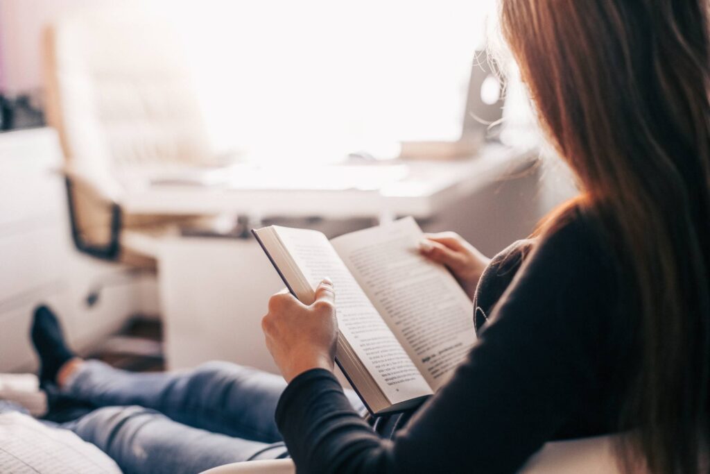 Girl Reading a Book at Home Free Photo