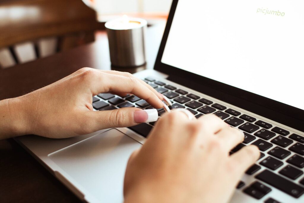 Girl Typing on MacBook Free Photo