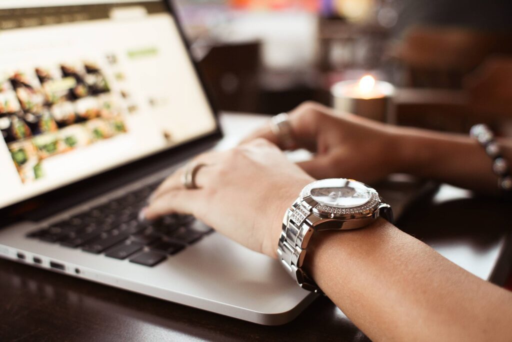 Girl with Watches Typing on MacBook Free Photo