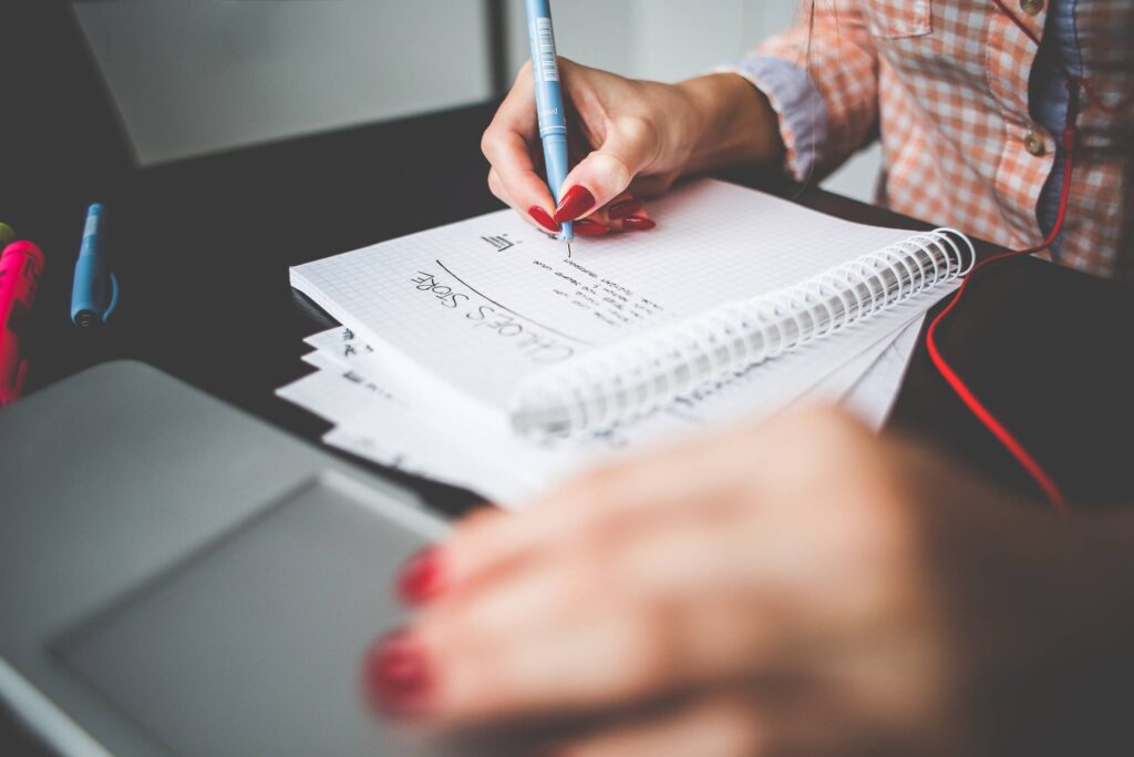 Girl Writing a Project To-Do Free Photo