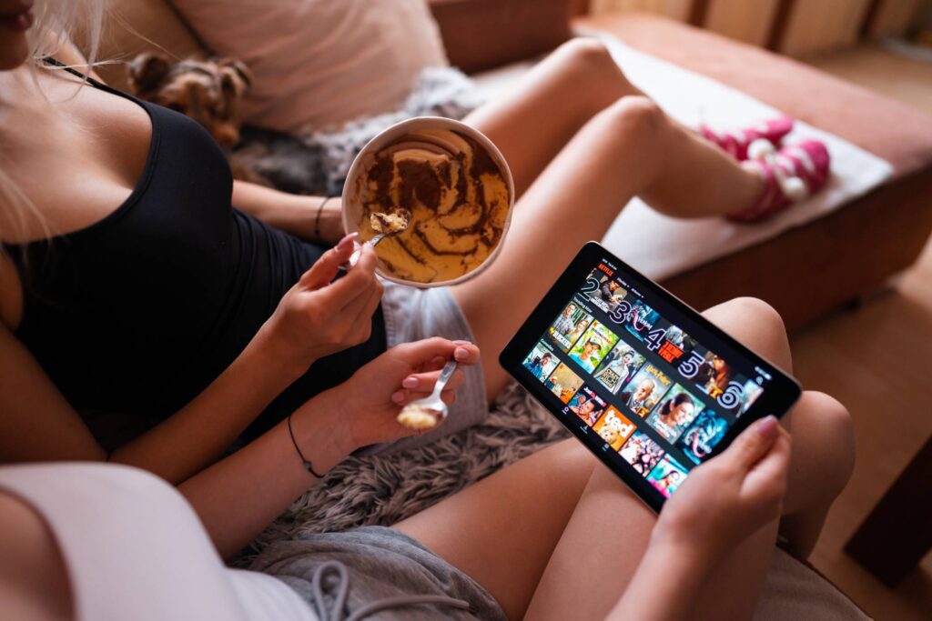 Girls Eating Ice Cream and Watching Netflix on a Tablet Free Photo