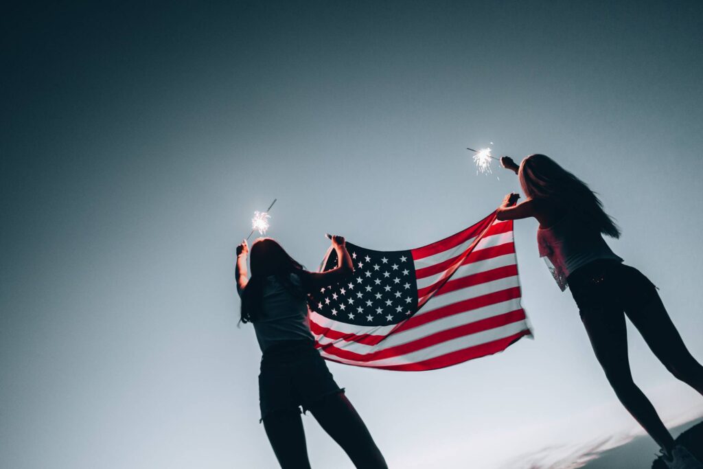 Girls Holding American Flag and Sparklers Free Photo