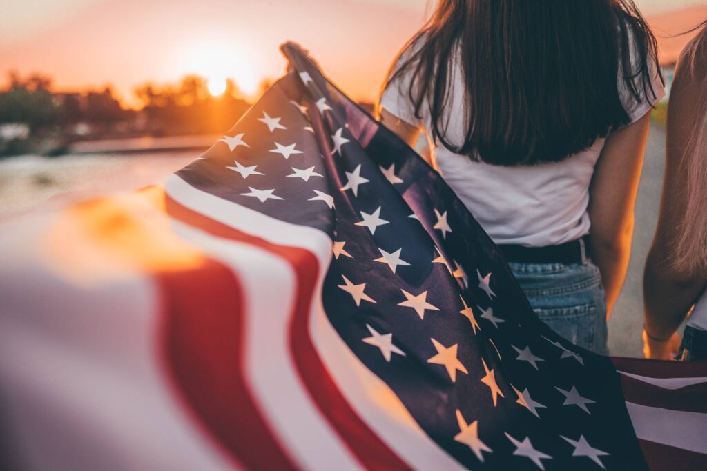 Girls Holding an American Flag Free Photo