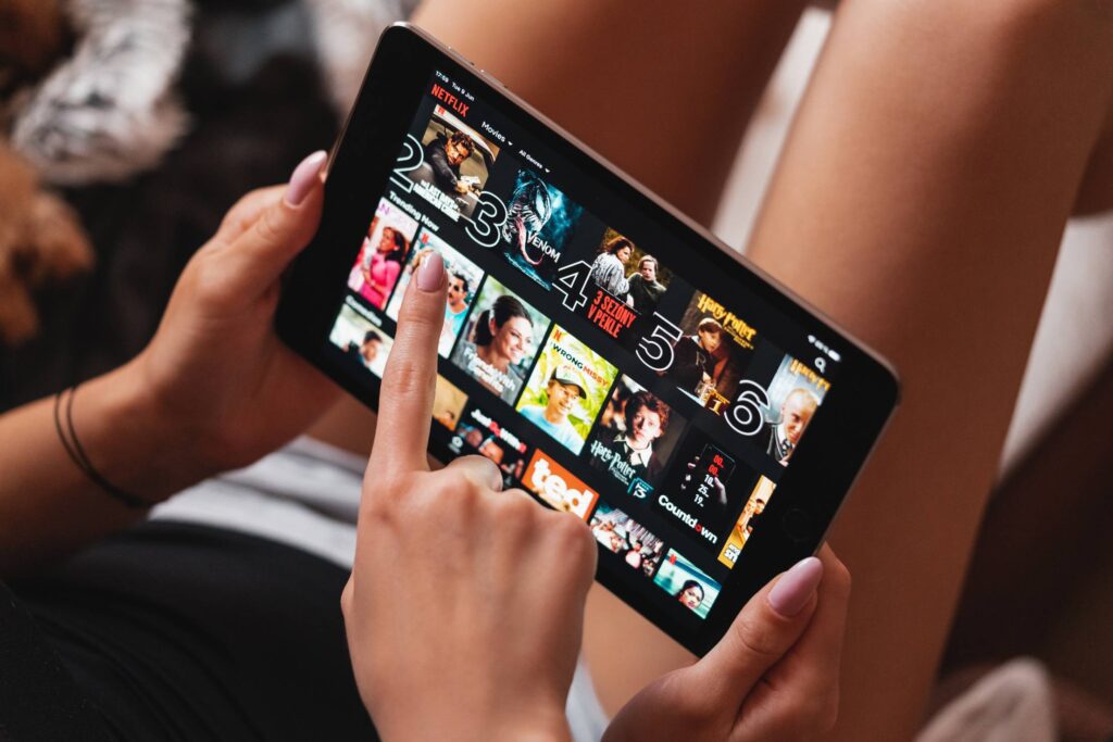 Girls Selecting Which Movie to Watch in Netflix App Free Photo