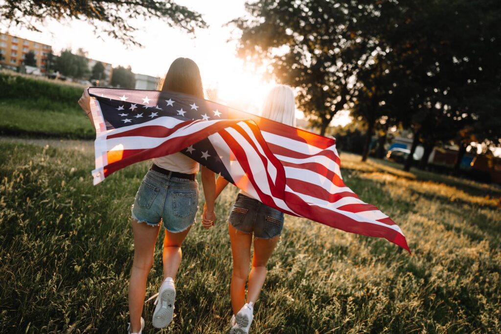 Girls with The American Flag Enjoying Independence Day Free Photo