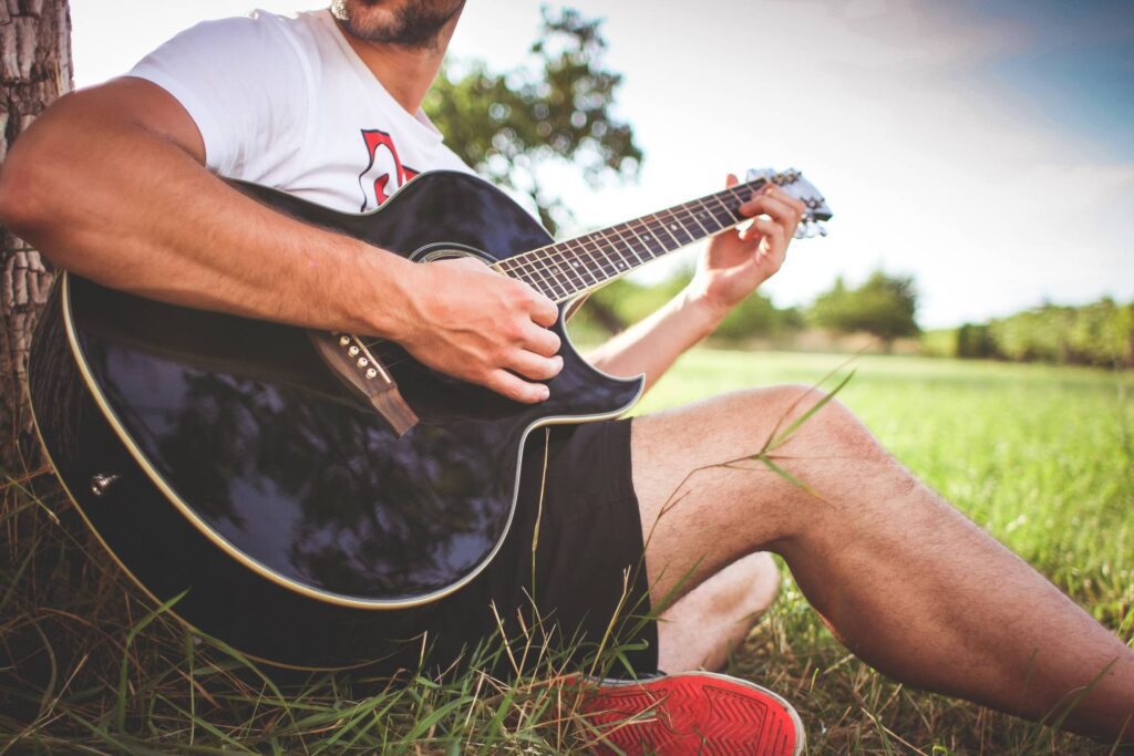 Guy Playing Acoustic Guitar in Nature Free Photo