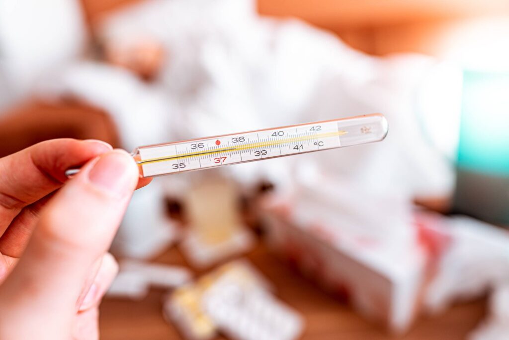 Hand Holding a Mercury Thermometer Free Photo