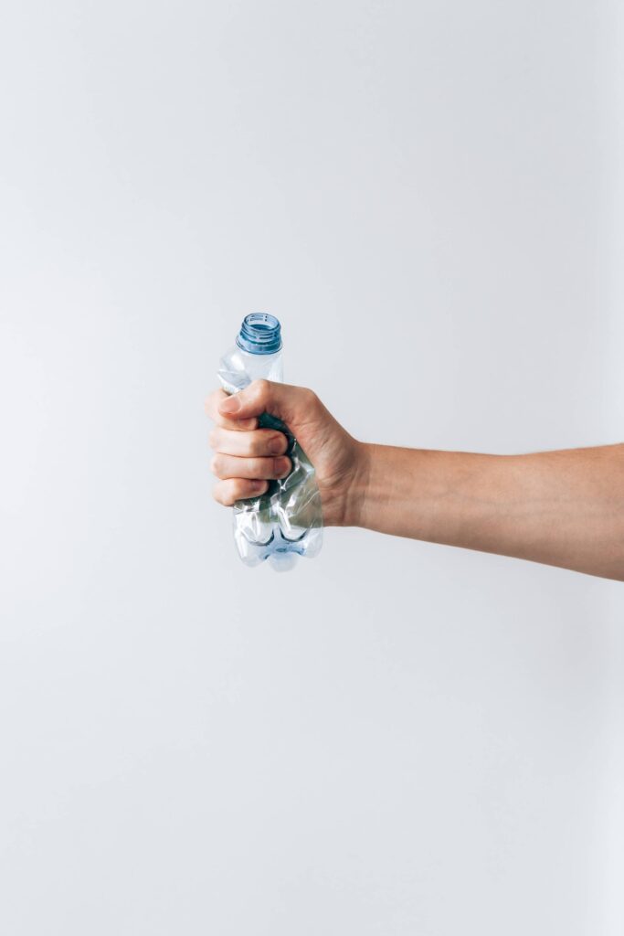 Hand Squeezing Empty Plastic Water Bottle Free Photo