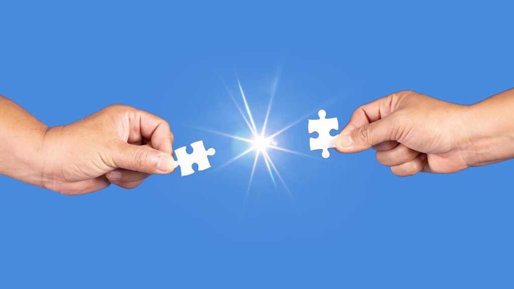 Hands holding jigsaw puzzles piece with clear blue background, success business, solution strategy, teamwork partnership concept Stock Free