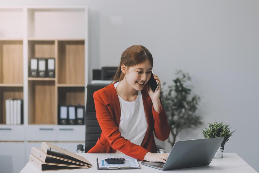 Happy excited asian business woman in office working with mobile phone,Yes great job. Stock Free