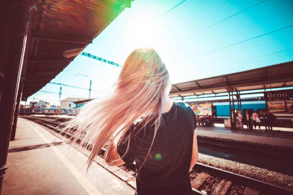 Happy Girl Enjoying Free Time & Waiting for Train Free Photo