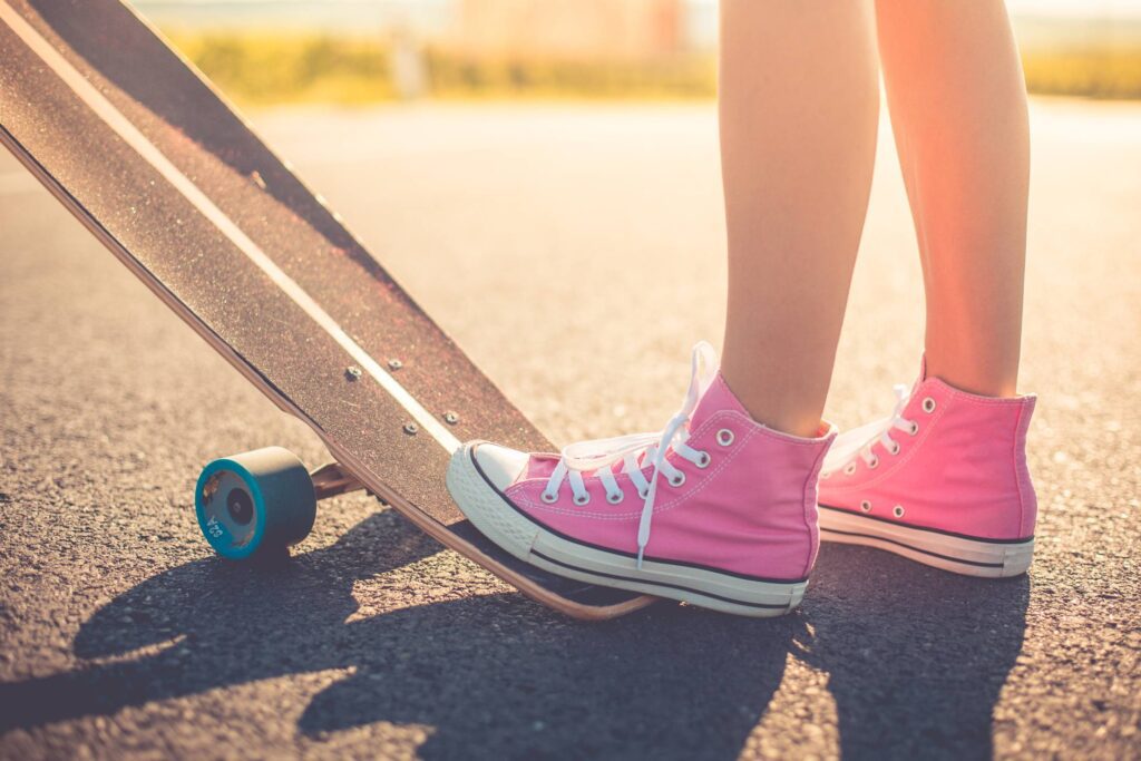 Happy Girl with Pink Shoes Ready to Longboard Ride Free Photo