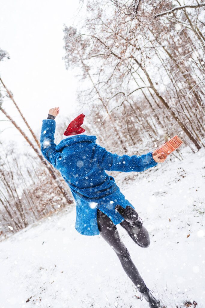 Happy Woman in Christmas Santa Hat Enjoying The Snowing Free Photo