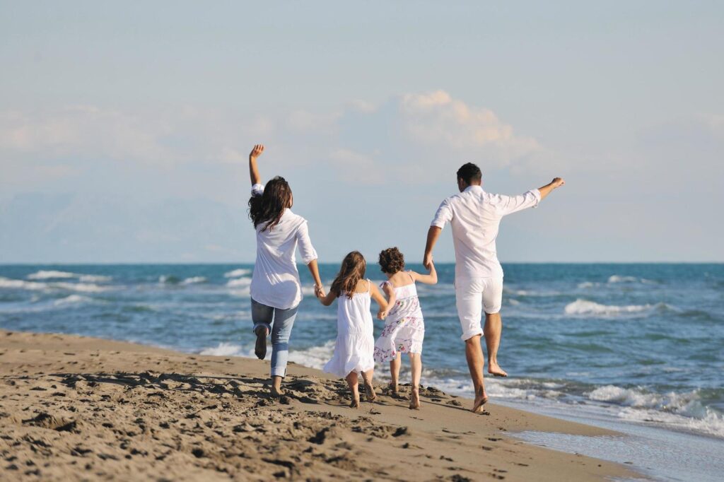 happy young family have fun on beach Free Photo