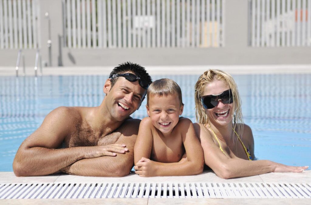 happy young family have fun on swimming pool Stock Free