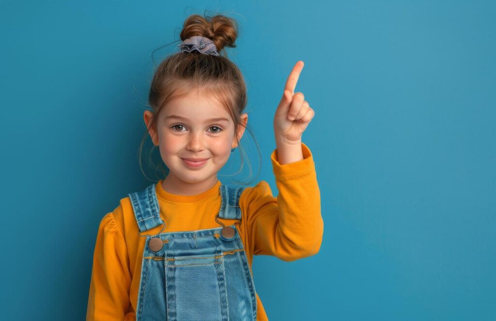 Happy Young Girl With Pigtails Points Up In Front Of Blue Background Stock Free