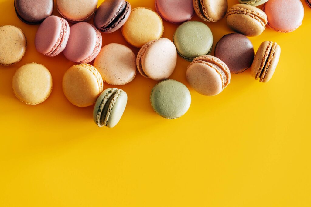 Homemade Colorful Macarons on Yellow Background Free Photo