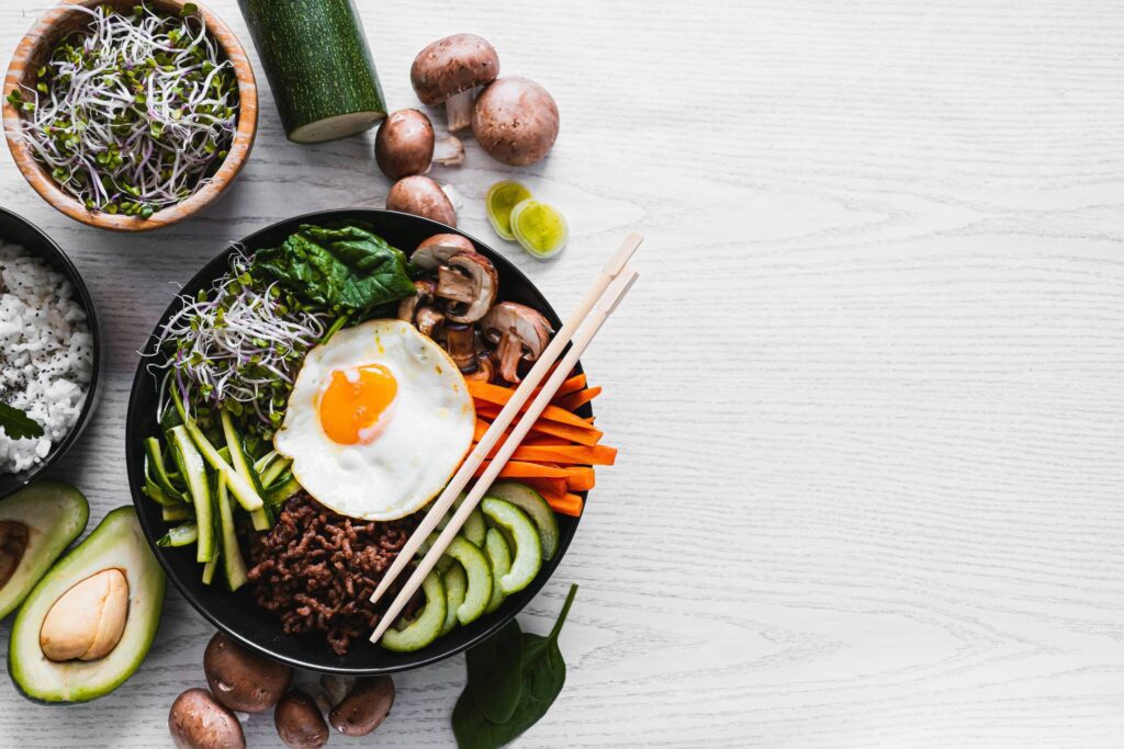 Korean Bibimbap on a White Table with a Space for Text Free Photo