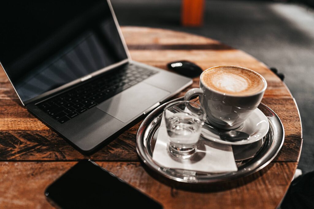 Laptop and Cappuccino on a Wooden Table Free Photo