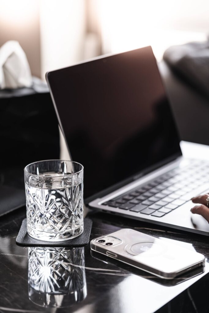 Laptop and Smartphone with a Crystal Glass of Water on a Luxury Marble Table Free Photo