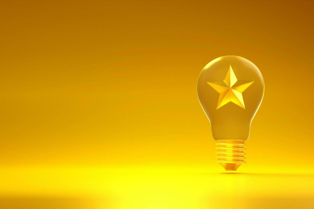 Light bulb with star icon on golden background with copy space. Stock Free