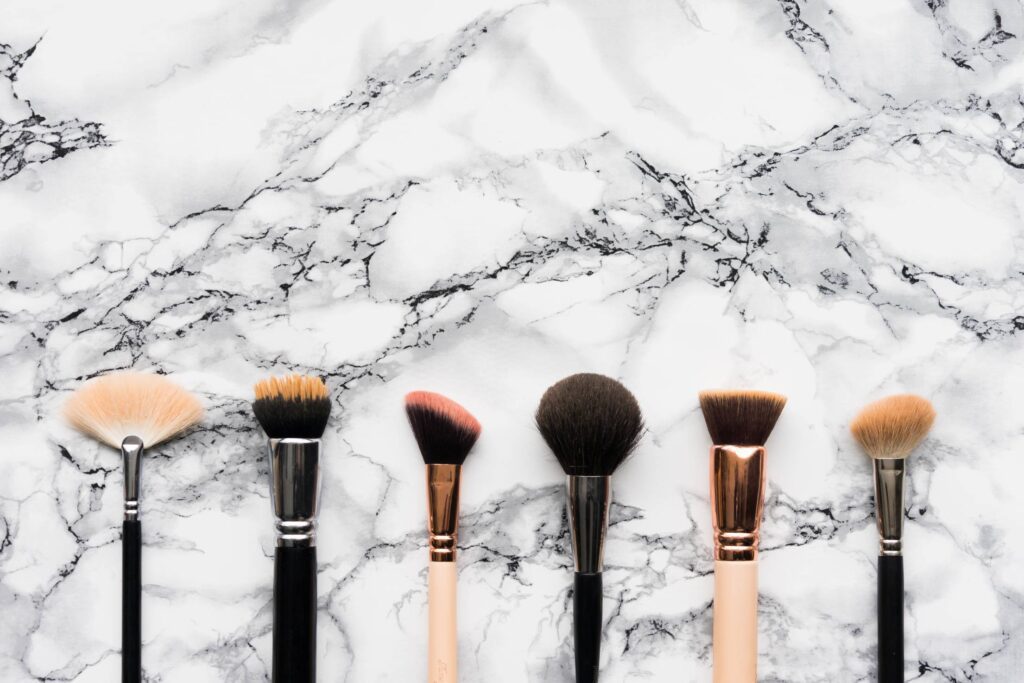 Makeup Brushes on White Marble Background Free Photo