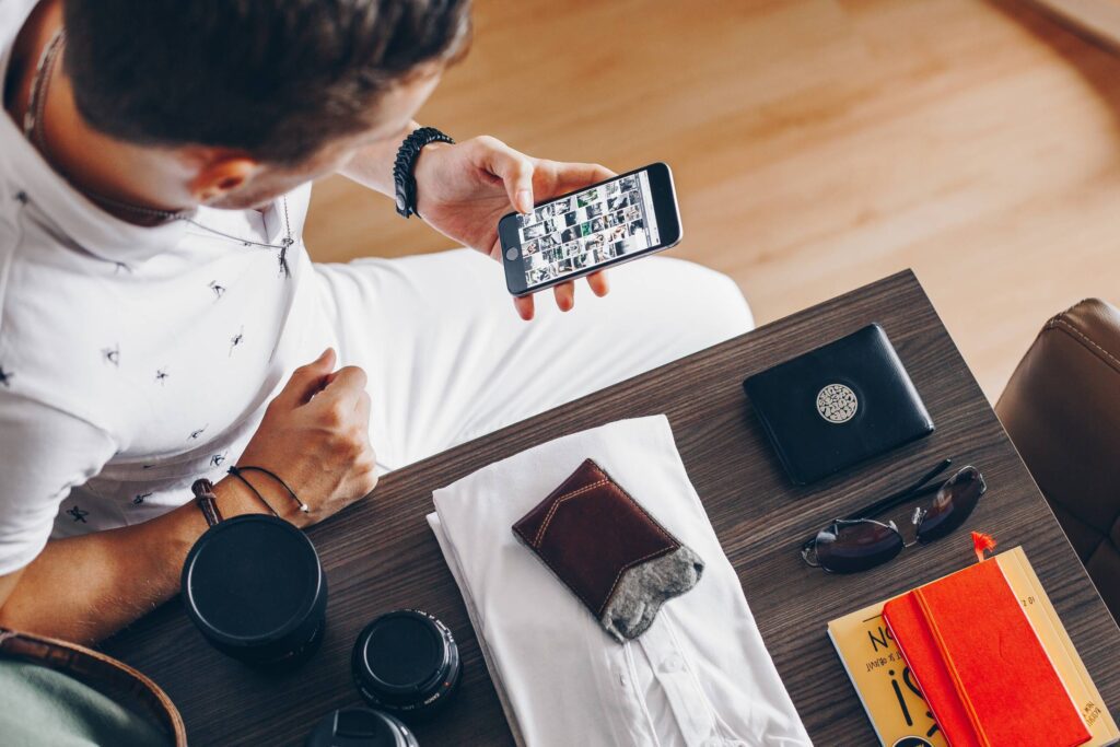 Man Browsing on His Phone While Packing Free Photo