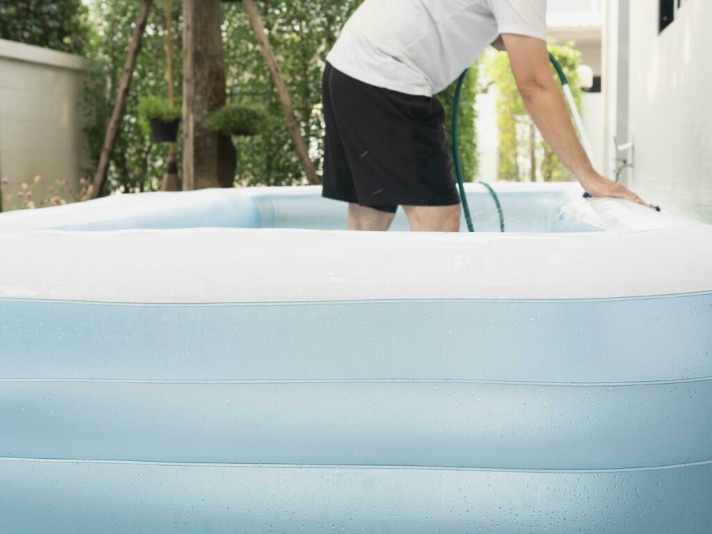 man clean big rubber toy pool – family lifestyle play at home activity Stock Free