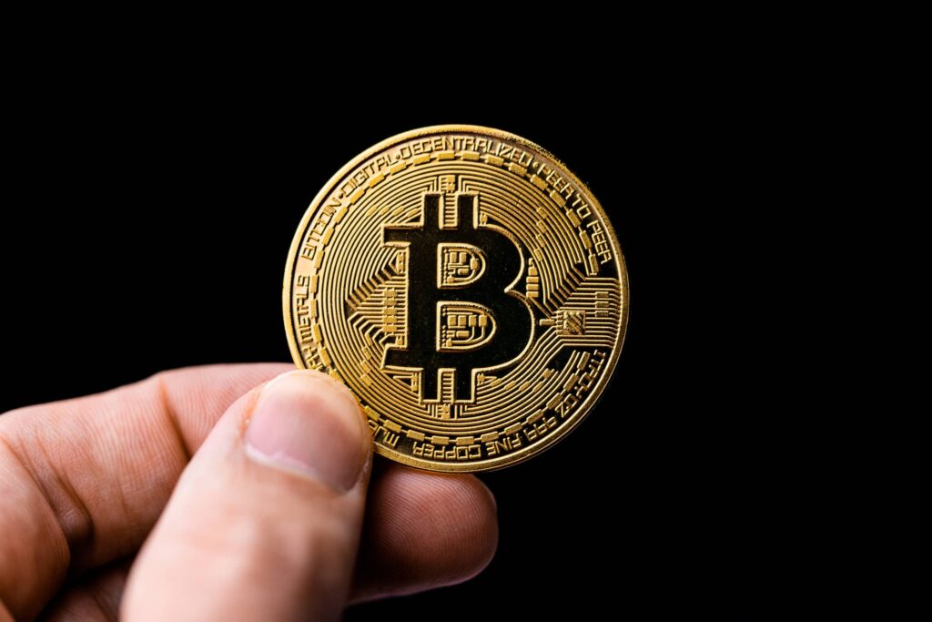 Man Holding a Bitcoin Coin Free Photo