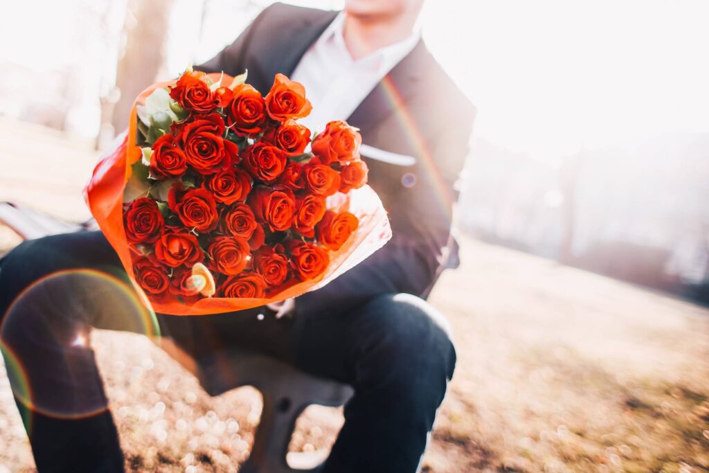 Man Holding a Bouquet of Red Roses Free Photo