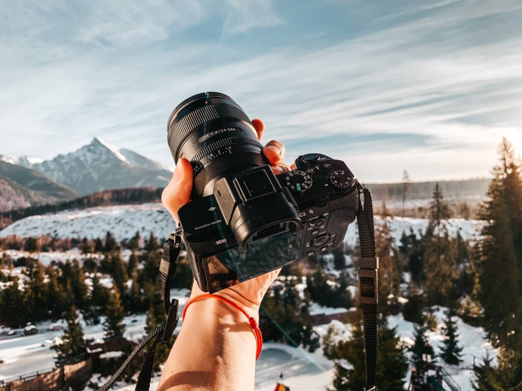 Man Holding a Camera in Mountains Free Photo