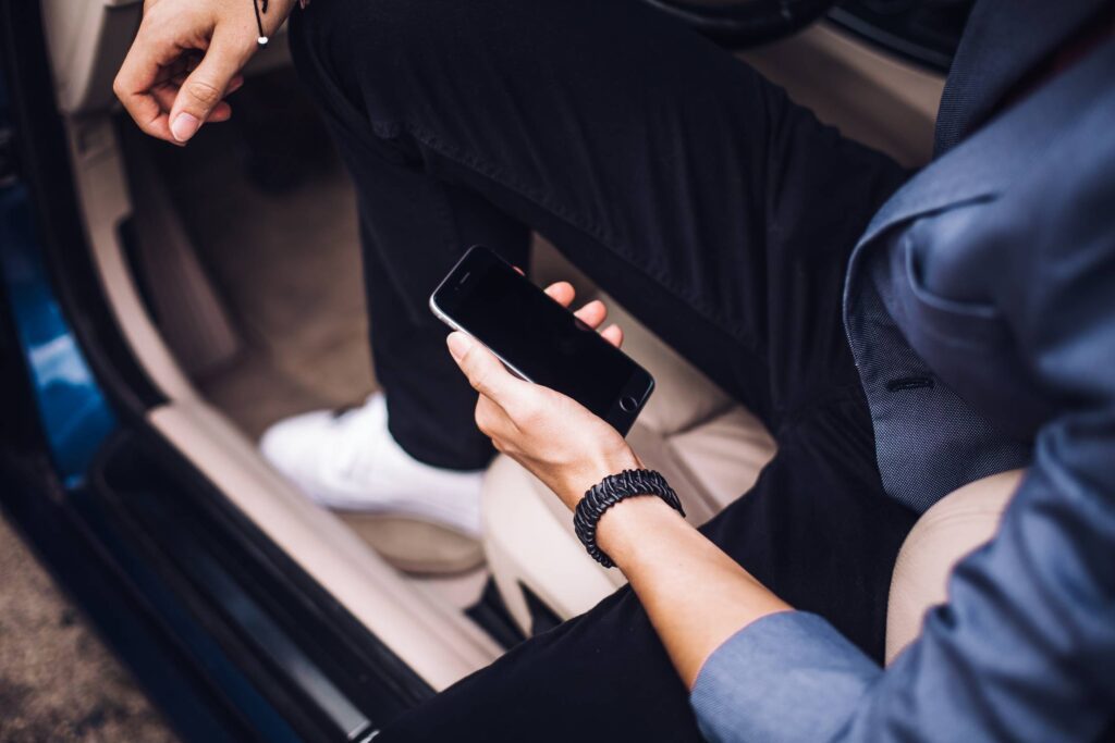 Man Holding iPhone in His Car Free Photo