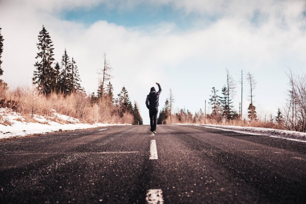 Man in a Winner Pose Walking on the Road Free Photo